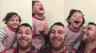 A father plays with his daughter and laughs every time a bomb goes off in Syria