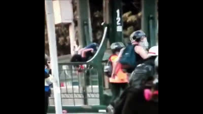 Chile Brutalidad Policial - Policía empuja a un manifestante por un puente
